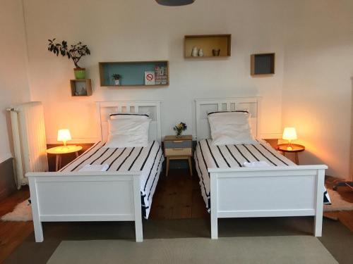 duas camas num quarto com duas lâmpadas em La Maison de famille em Boën