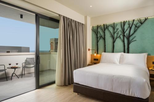 a bedroom with a bed and a large window at Hyperion City Hotel & Spa in Chania Town