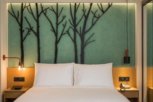 a bed with a white bedspread and a white head board at Hyperion City Hotel & Spa in Chania