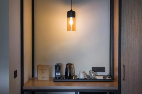 a light hanging over a table with a coffee maker at Hyperion City Hotel & Spa in Chania Town