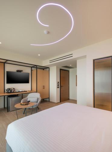 a hotel room with a large bed and a tv at Hyperion City Hotel & Spa in Chania Town