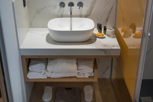 a bathroom with a sink and towels on a counter at Hyperion City Hotel & Spa in Chania Town