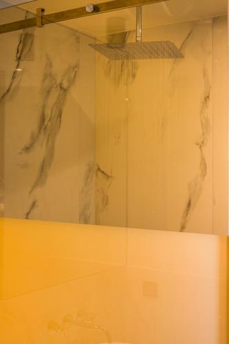 a bathroom with a shower with a sink at Hyperion City Hotel & Spa in Chania Town