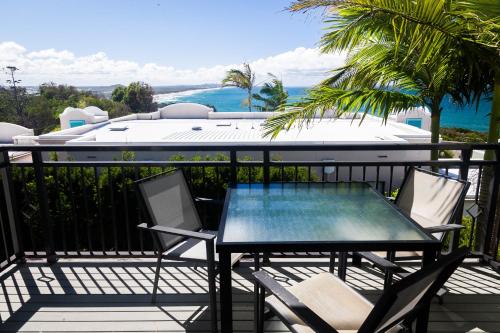 a table and chairs on a balcony with a view of the ocean at The Point Coolum in Coolum Beach