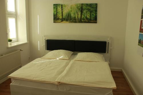 een bed in een slaapkamer met een foto aan de muur bij Ferienwohnung Altstadtdomizil in Wernigerode
