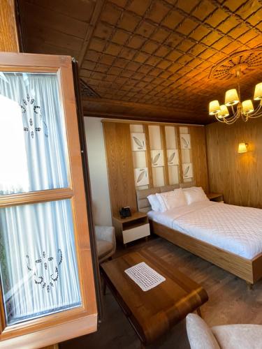 a bedroom with a large bed and a window at KERCULLA Resort in Gjirokastër