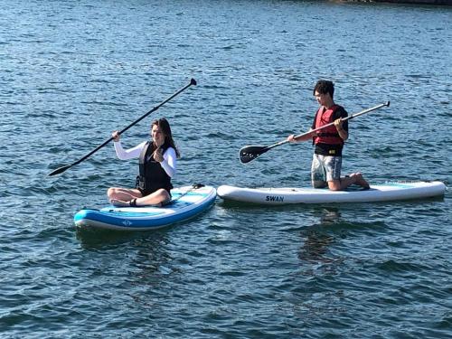 two people are on paddle boards in the water at Marinan Richters in Fjällbacka