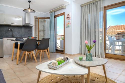 eine Küche und ein Wohnzimmer mit einem Tisch und Stühlen in der Unterkunft Calma Guest House in Ierissós