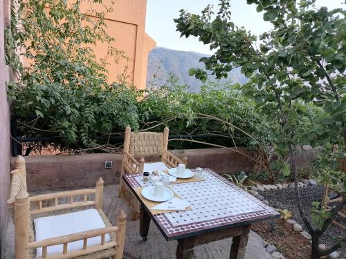 einen Tisch und Stühle auf einer Terrasse mit Aussicht in der Unterkunft Chambre d'hôtes aya in Ouzoud