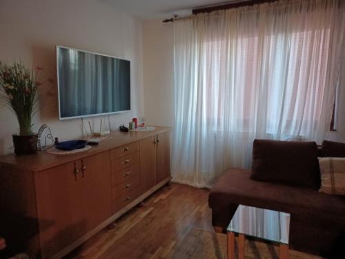 a living room with a television on top of a dresser at Walk Apartment in Vukovar