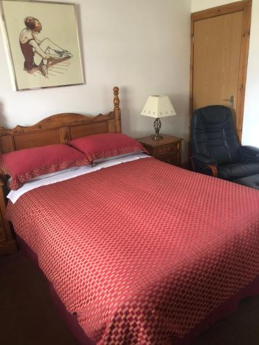 1 dormitorio con 1 cama roja y 1 silla azul en Room @ Jasmine Cottage en Bathgate