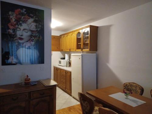a kitchen with a table and a white refrigerator at Walk Apartment in Vukovar