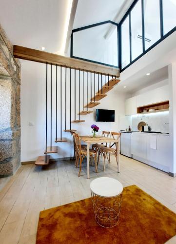 a living room with a dining room table and a staircase at Lodges Minho in Ponte da Barca