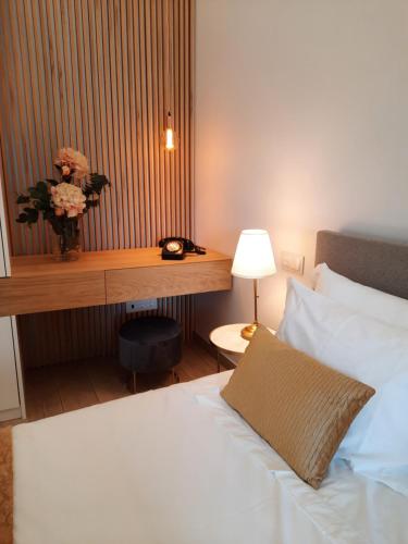 a bedroom with a bed and a desk with a vase of flowers at Lodges Minho in Ponte da Barca