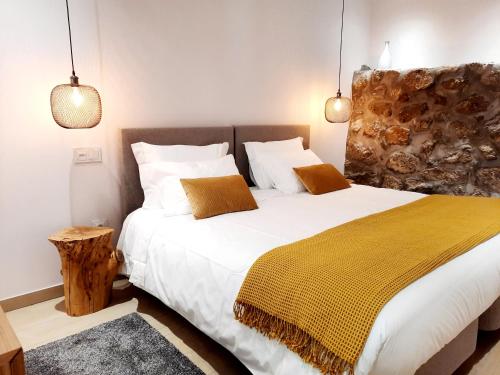 a bedroom with a large bed with a yellow blanket at Lodges Minho in Ponte da Barca