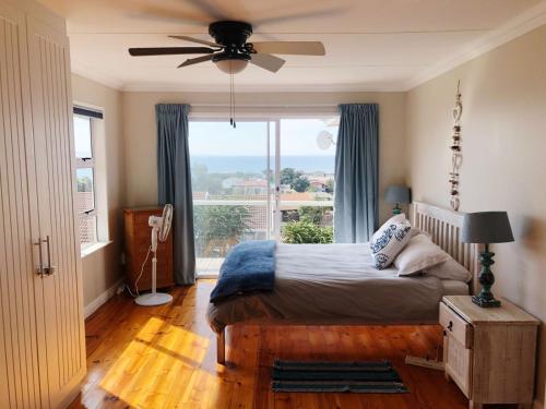 a bedroom with a bed and a large window at Casa Surf Lodge J'Bay in Jeffreys Bay