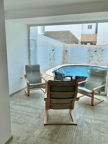 a living room with a pool and two chairs and a table at Hostal Rosalia in San Antonio