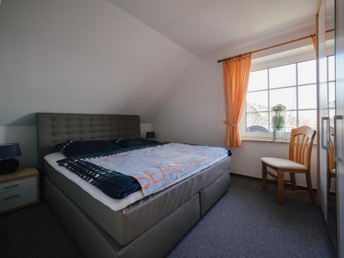 a bedroom with a bed and a window and a chair at Seaside 26 in Friedrichskoog