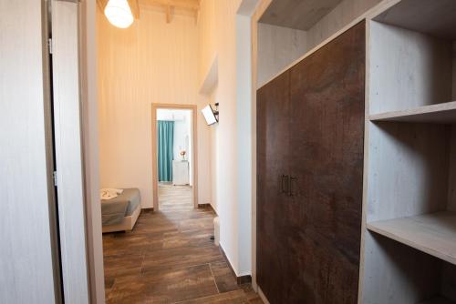 a hallway with a room with a bed and a door at Angela Beach Hotel & Apts in Roda