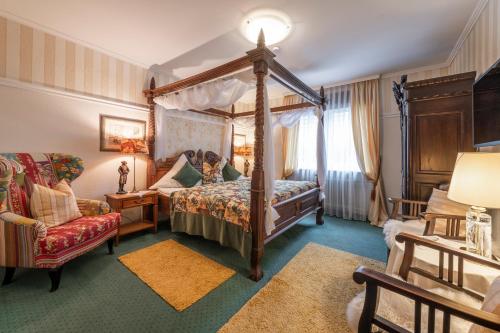 1 dormitorio con cama con dosel y silla en Pension Zweck en Gößweinstein