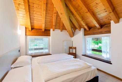 a bedroom with two beds and two windows at Casa Alberta in Pieve Di Ledro