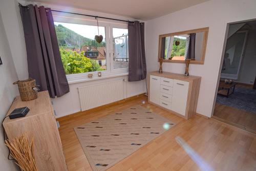 a living room with a large window and a dresser at Ferienwohnung Bergblick -KEINE MONTEURE- in Goslar
