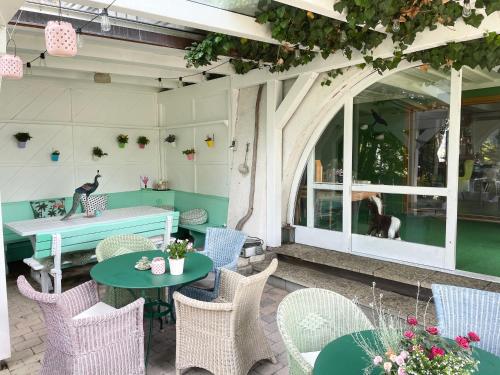 a patio with tables and chairs and a cat in the window at VILLA OXA - Boutique Design Hotel in Maria Alm am Steinernen Meer