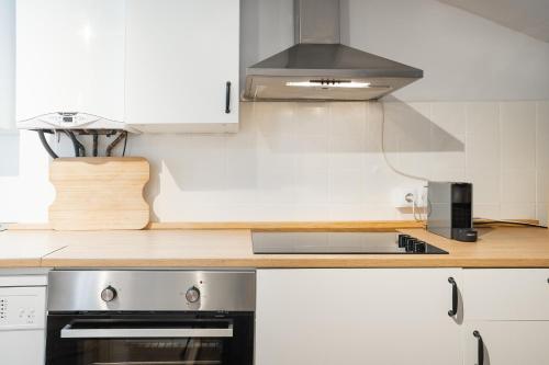 a kitchen with white cabinets and a stove top oven at Txori-Toki in Zarautz