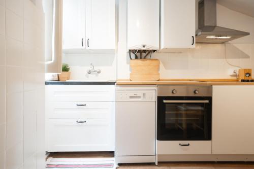 a kitchen with white cabinets and a black oven at Txori-Toki in Zarautz