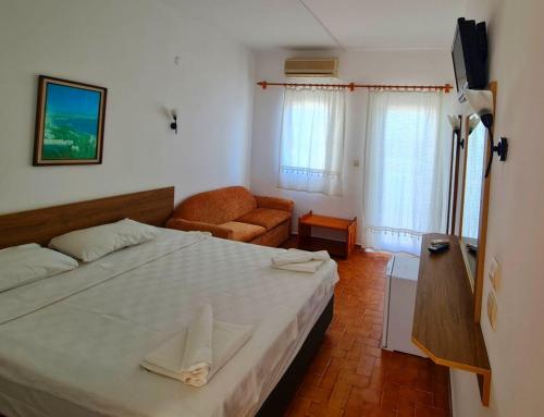 um quarto com uma cama grande e um sofá em Nagi Beach Hotel em Gümbet