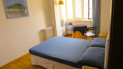 Un dormitorio con una cama y una mesa y sillas. en Luna Rossa Rooms, en Cagliari