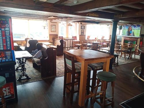 a bar with tables and chairs in a restaurant at The Royal Oak in Weymouth