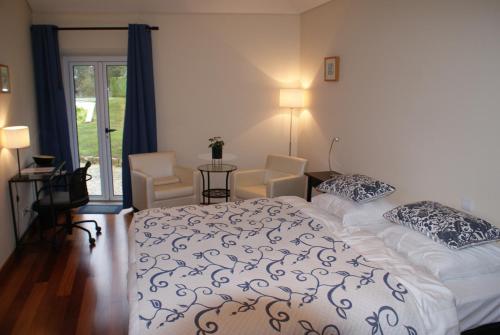 a bedroom with a bed and a table and chairs at Casa Águas Mansas in Cadima