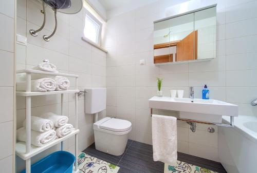 a white bathroom with a toilet and a sink at Apartment Anja in Krk