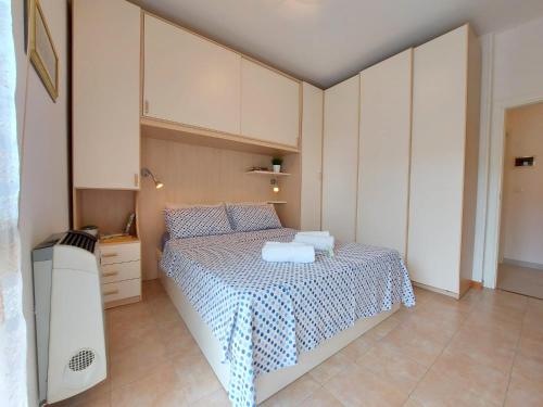 a bedroom with a bed with a blue and white blanket at Serena 2-8 in Lido di Pomposa