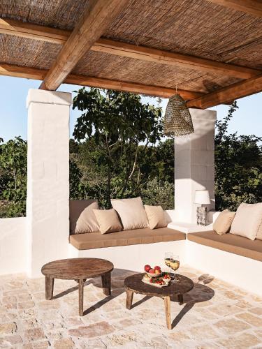 a patio with a couch and a table at Trulli Del Bosco in Alberobello