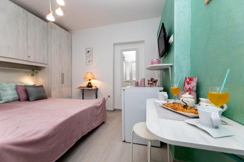 ein Schlafzimmer mit einem Bett und einem Tisch mit Essen darauf in der Unterkunft Room Gržetić in Šilo