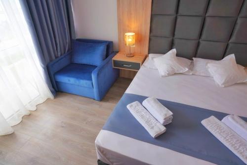 a bedroom with a bed and a blue chair at Hotel Opal in Jupiter