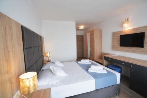 a hotel room with a bed and a television at Hotel Opal in Jupiter