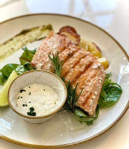a plate of food with salmon and a bowl of dip at Hotel Starkl - Heritage & Unique in Bled