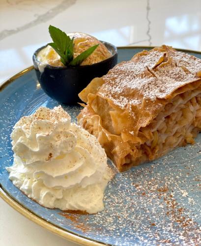 a blue plate with pie and whipped cream on it at Hotel Starkl - Heritage & Unique in Bled