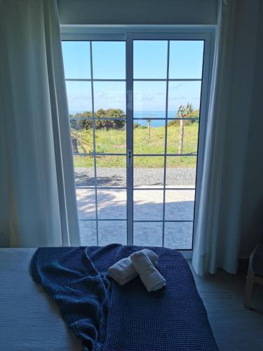 a bedroom with a bed and a large window at Houses of Eira Velha in Fajã do Ouvidor