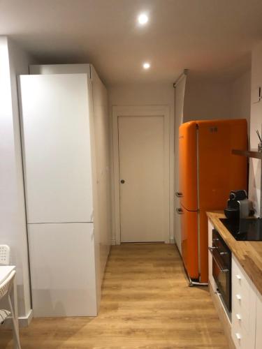 a kitchen with a white refrigerator and an orange door at BET Apartments - Tramontana Apartments in Valencia