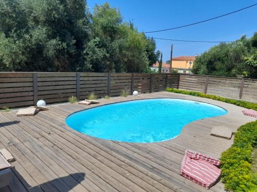 a swimming pool on a wooden deck with a wooden fence at Diogenis Villa in Argostoli
