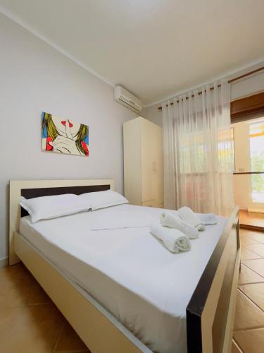 Beach Apartaments في دوريس: غرفة نوم بها سرير أبيض كبير مع مناشف عليه
