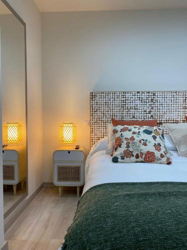 a bedroom with a large bed and two lamps at Puntos cardinales in Los Corrales de Buelna
