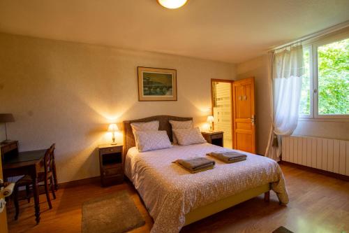 une chambre avec un lit, un bureau et une fenêtre dans l'établissement La Maison d'Élise, à Sarlat-la-Canéda