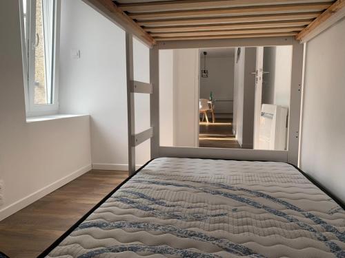 Schlafzimmer mit einem Bett und einem großen Spiegel in der Unterkunft Appartement calme et chaleureux in Concarneau