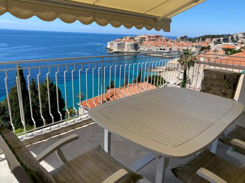 a table on a balcony with a view of the ocean at Pearl of Adriatic in Dubrovnik