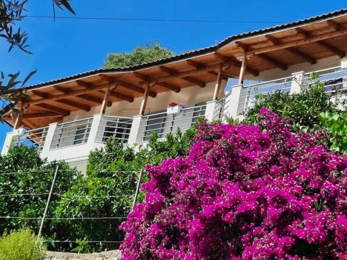 a house with pink flowers in front of it at Eduard Lagji Apartament in Lukovë